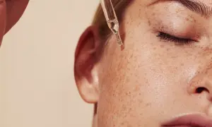Kropla serum z pipety spada na piegowatą skórę. Czy to retinol? Co to jest retinol i jak działa na skórę?