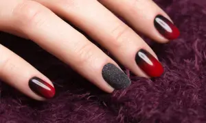 Eleganckie paznokcie do czarnej sukienki: ombre z czerwieni i czerni, jeden paznokieć w czarnym brokatowym macie.