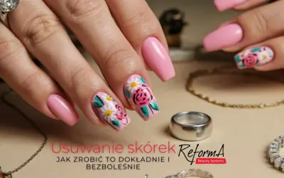 Dłoń z różowymi paznokciami ozdobionymi kwiatami. Delikatne kopytko i biżuteria dopełniają stylizację.
