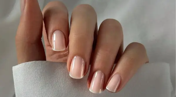 Delikatne, klasyczne modne paznokcie na wiosnę w stylu francuskim, z subtelnym różowym odcieniem i białymi końcówkami.