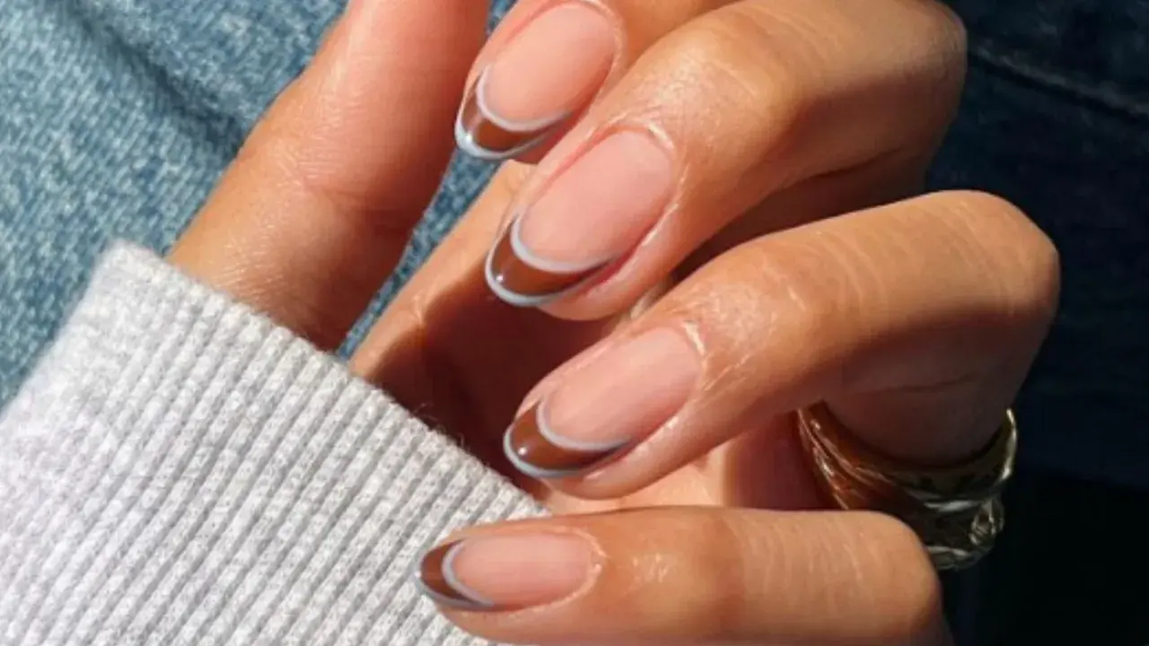 Elegancki francuski manicure z brązowo-niebieskimi końcówkami.