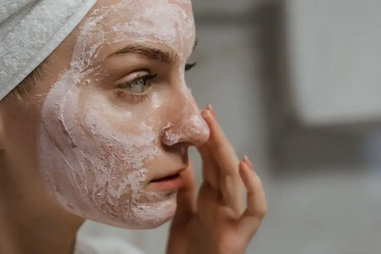 Kobieta z maseczką na twarzy, która pomaga regulować nadmiar sebum.