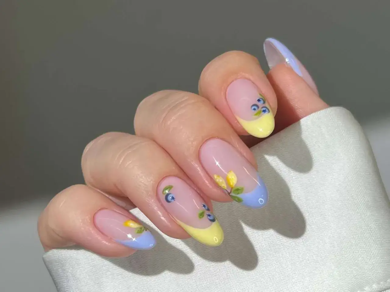 Delikatny french manicure w stylu francuskim, z motywem jagód i kwiatów. Kolory pastelowe, idealne na wiosnę.